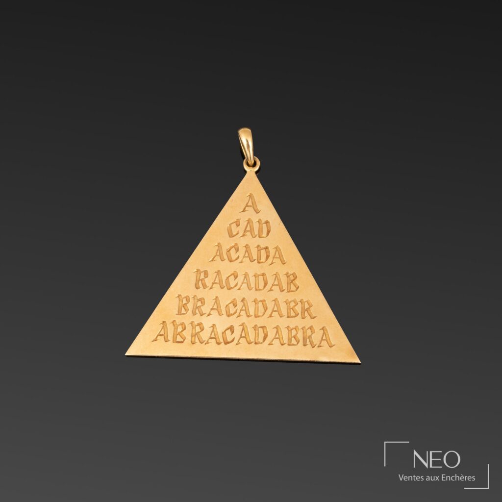 Pendentif triangulaire en or jaune gravé du mot Abracadabra