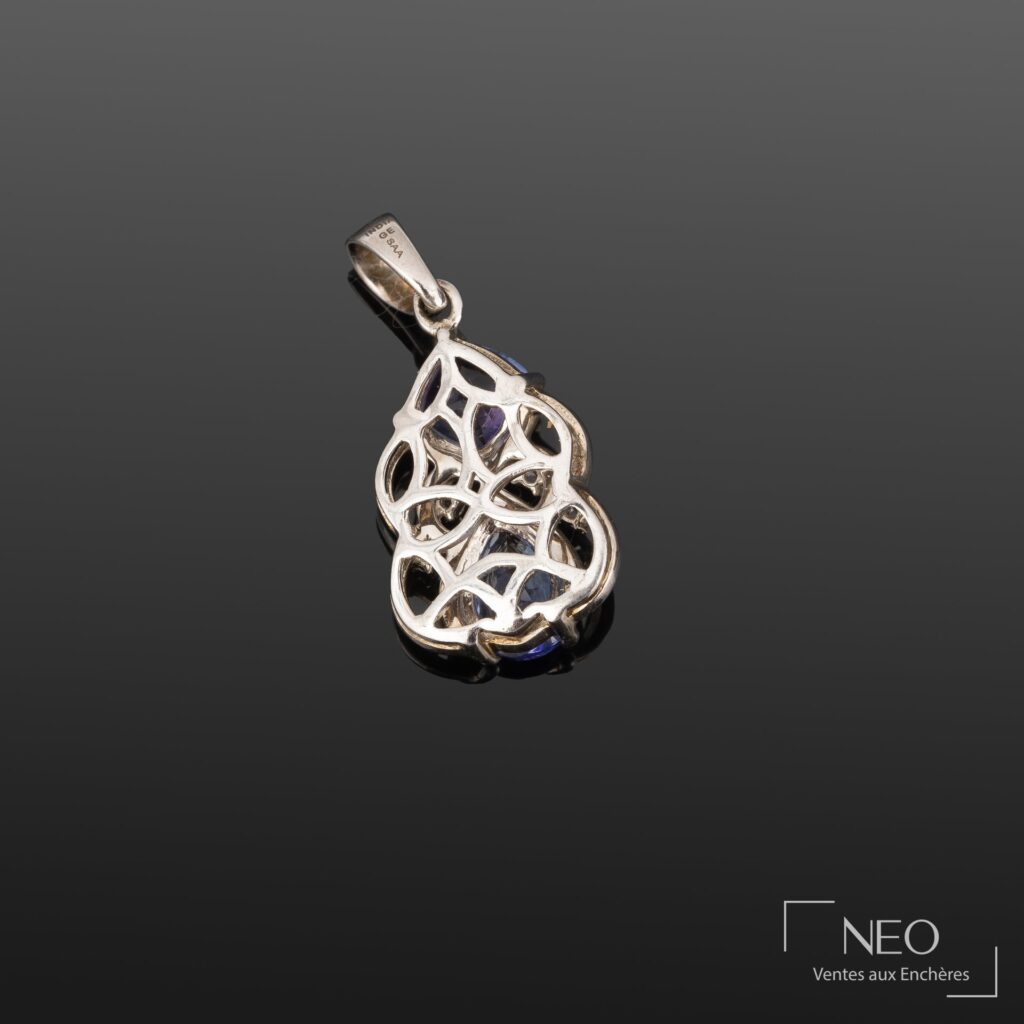 Revers d'un pendentif ajouré en argent avec monture ouverte et pierres bleues visibles dessous