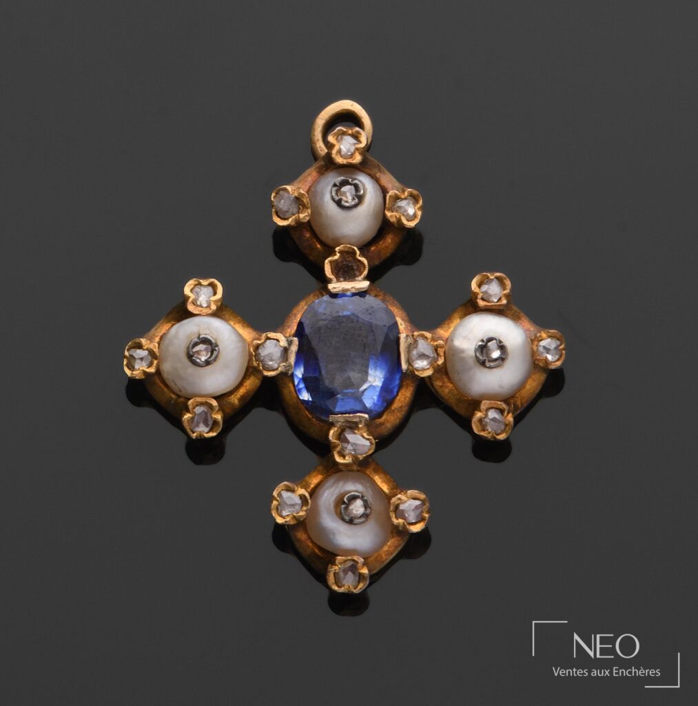 Pendentif croix en or jaune serti d'une pierre bleue et de pierres blanches