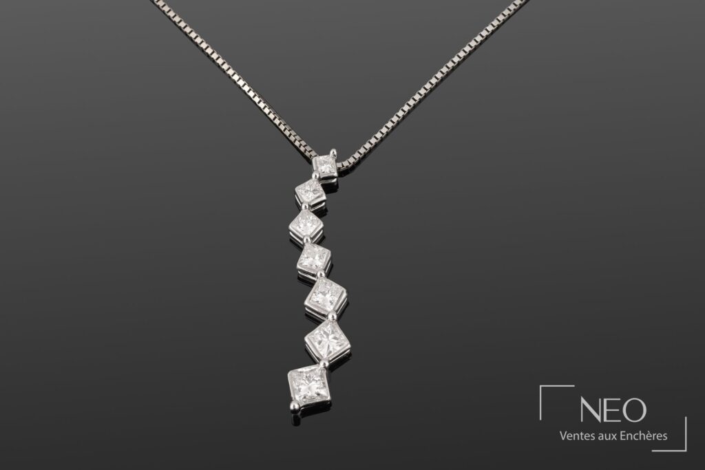 Pendentif en chute de sept diamants taille princesse sur chaîne en or blanc