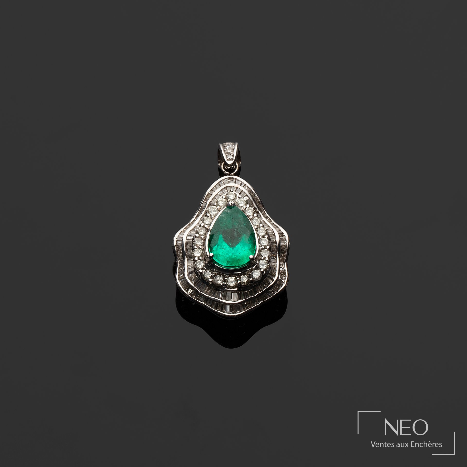 Pendentif en or gris serti d’une émeraude poire entourée de diamants