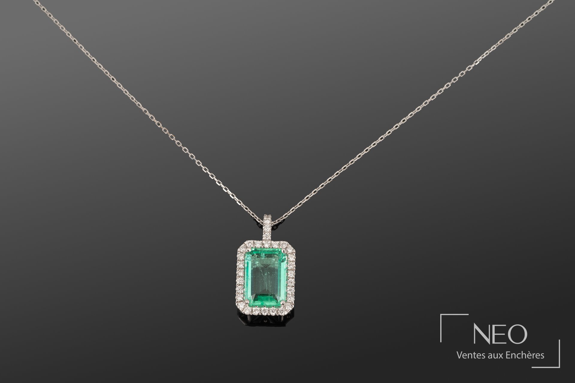 Pendentif en or blanc avec émeraude rectangulaire entourée de diamants