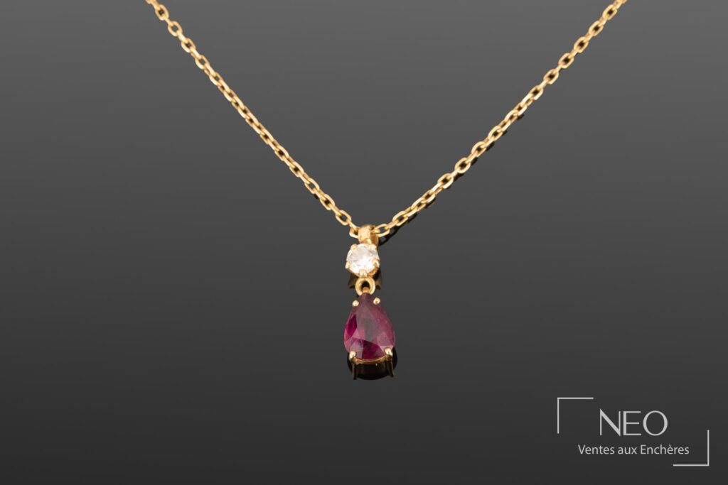 Pendentif en or jaune avec diamant et pierre rouge en poire sur sa chaîne