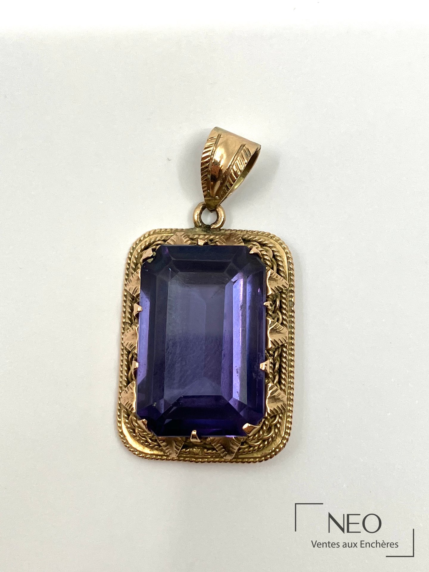 Pendentif en or jaune serti d'un grand verre violacé rectangulaire