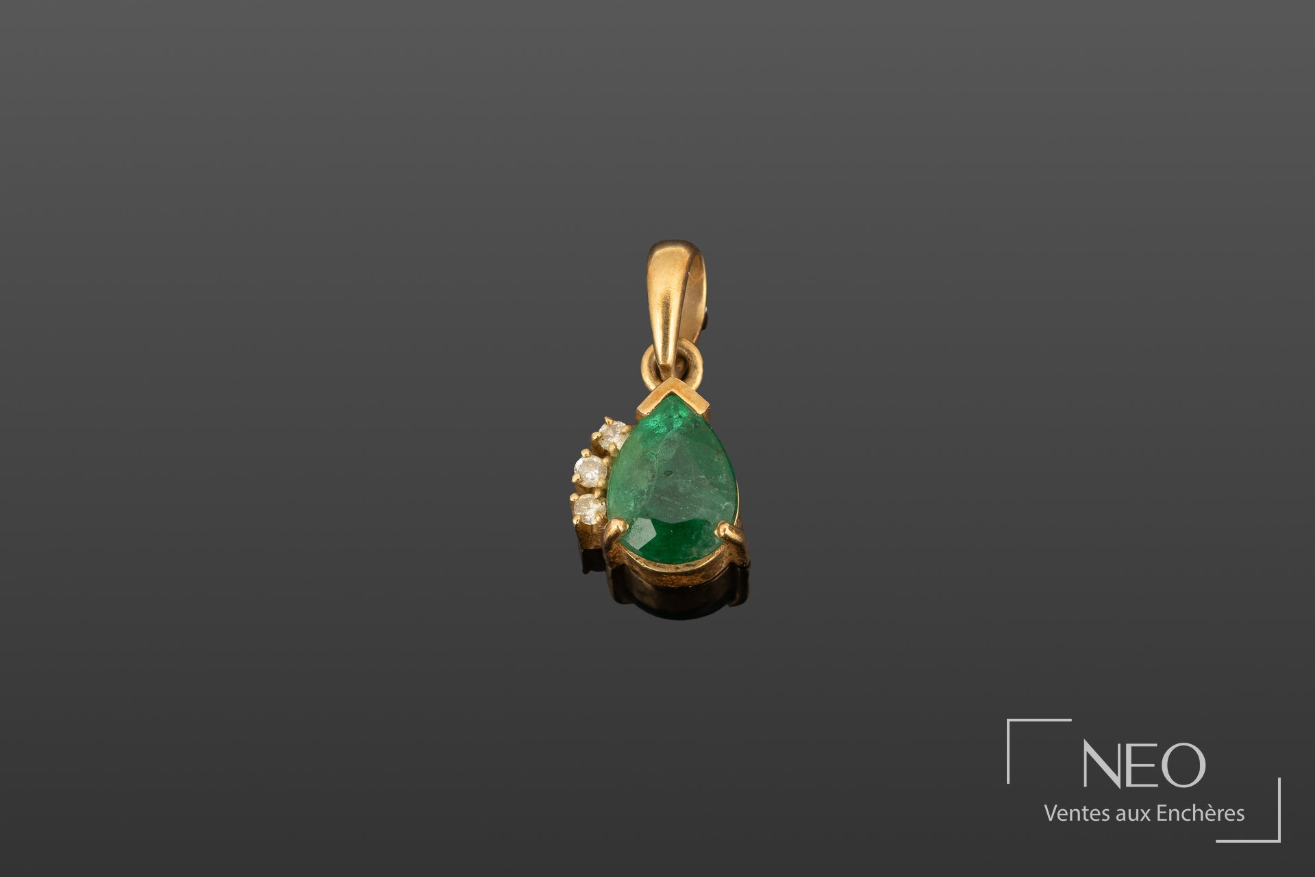 Pendentif en or jaune 18K serti d’une émeraude poire et de trois diamants