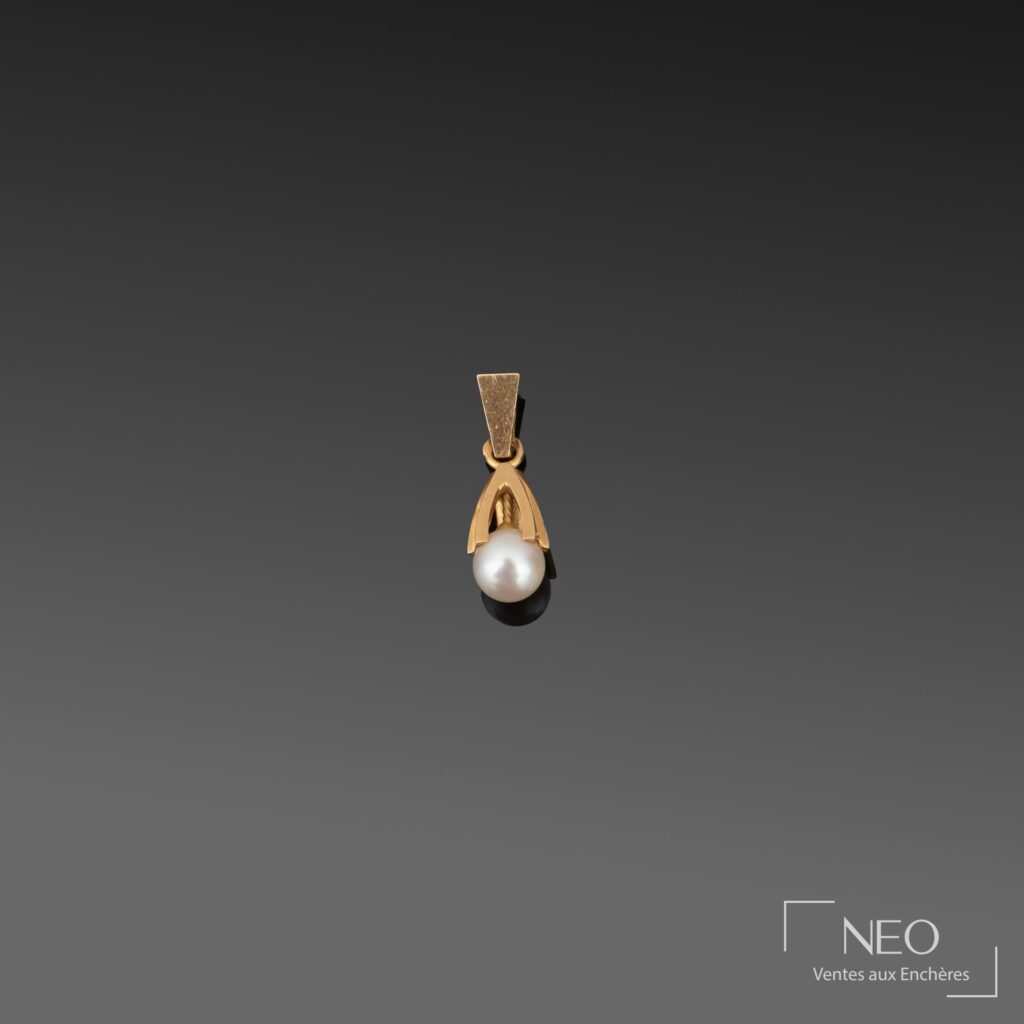 Pendentif en or jaune retenant une perle de culture blanche