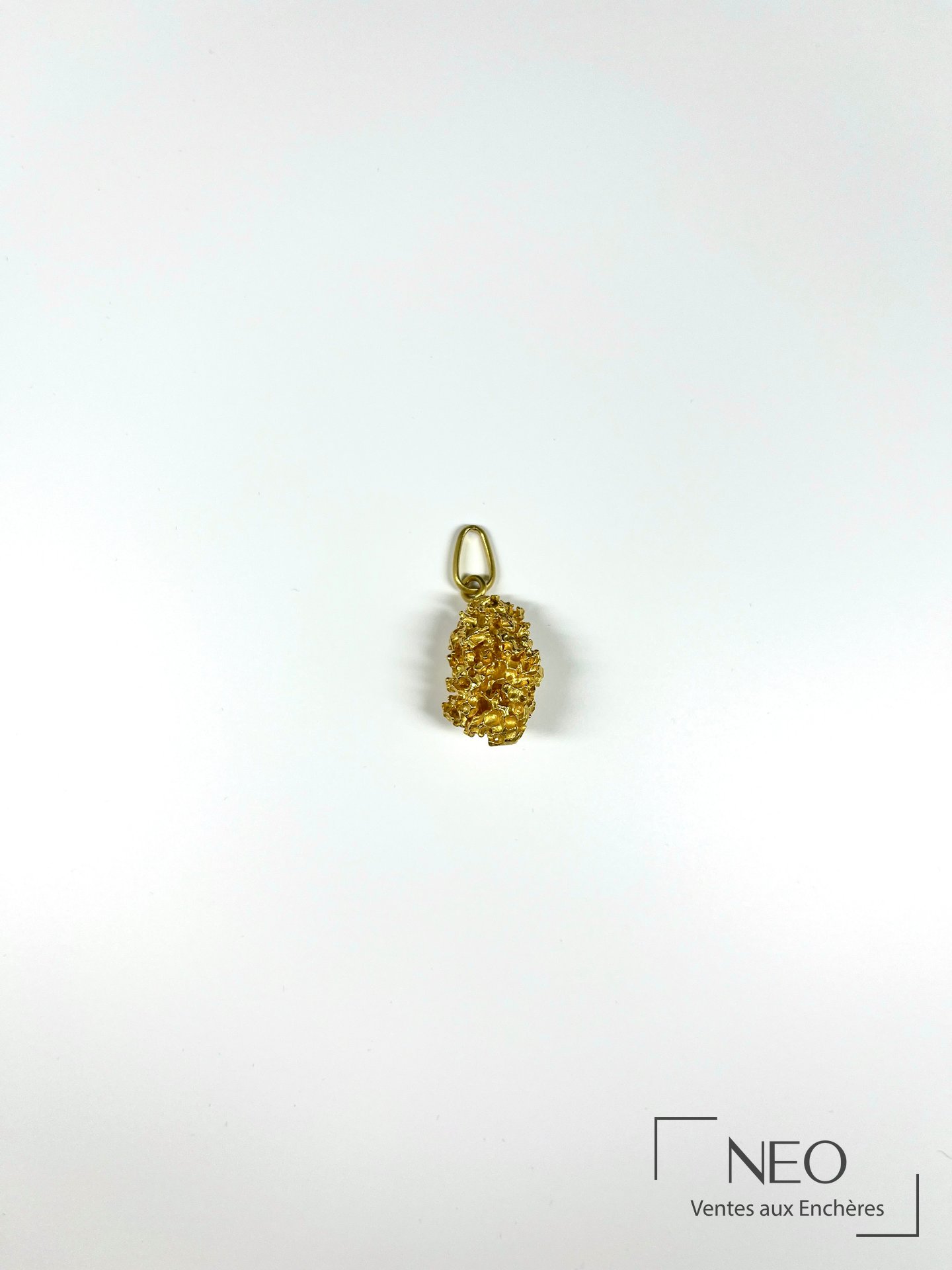 Pendentif pépite en or jaune vu de face sur fond blanc