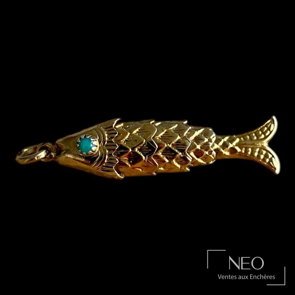 Pendentif poisson articulé en or jaune avec œil serti d'une pierre verte