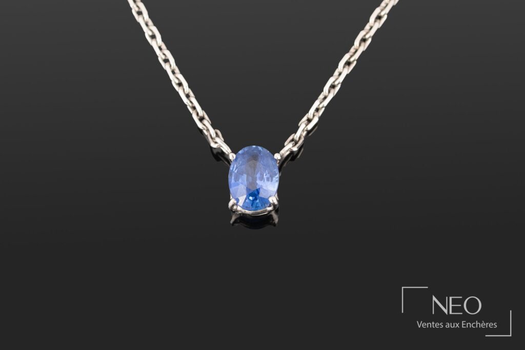 Pendentif en or blanc serti d’un saphir ovale sur chaîne maille forçat