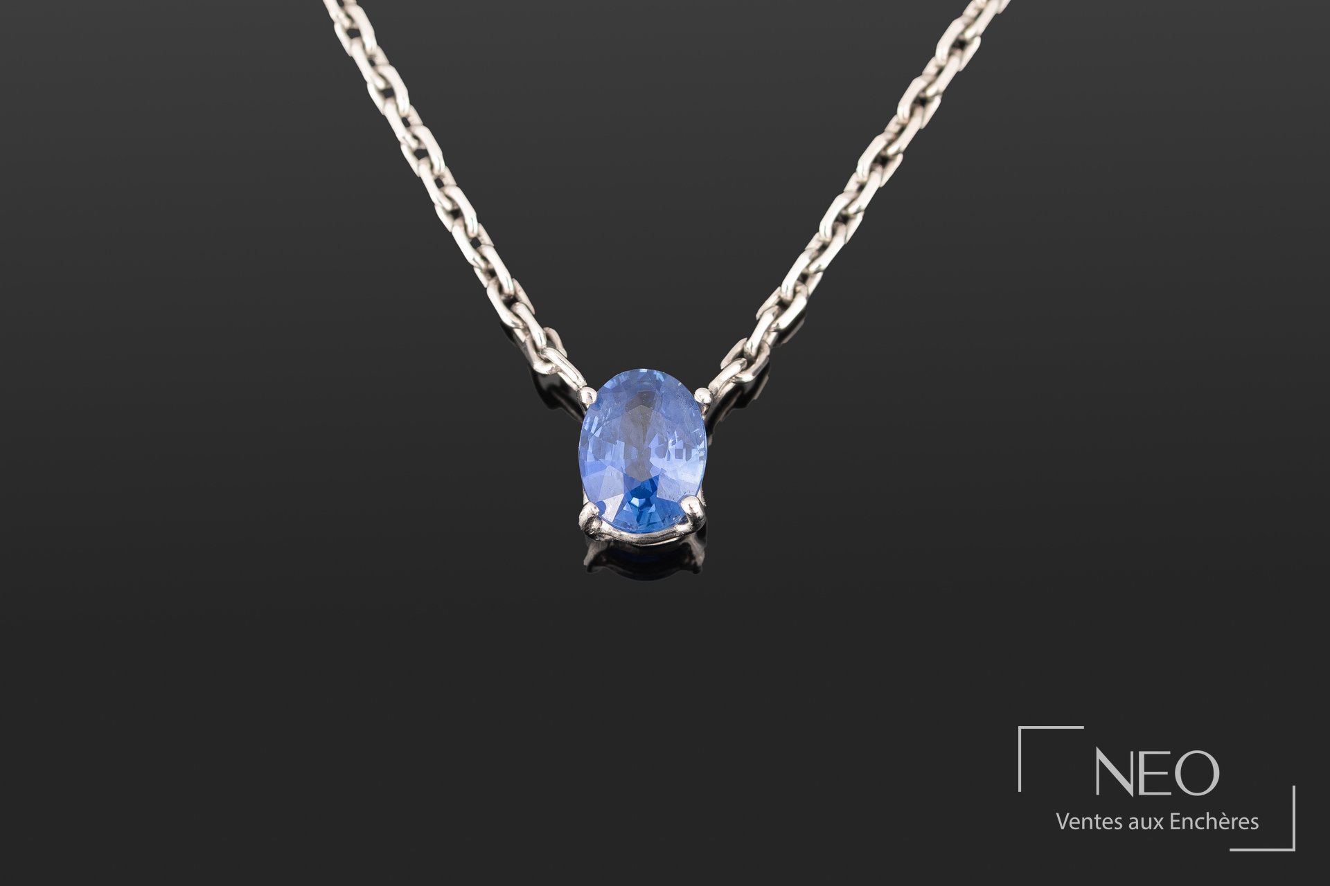 Pendentif en or blanc serti d’un saphir ovale sur chaîne maille forçat