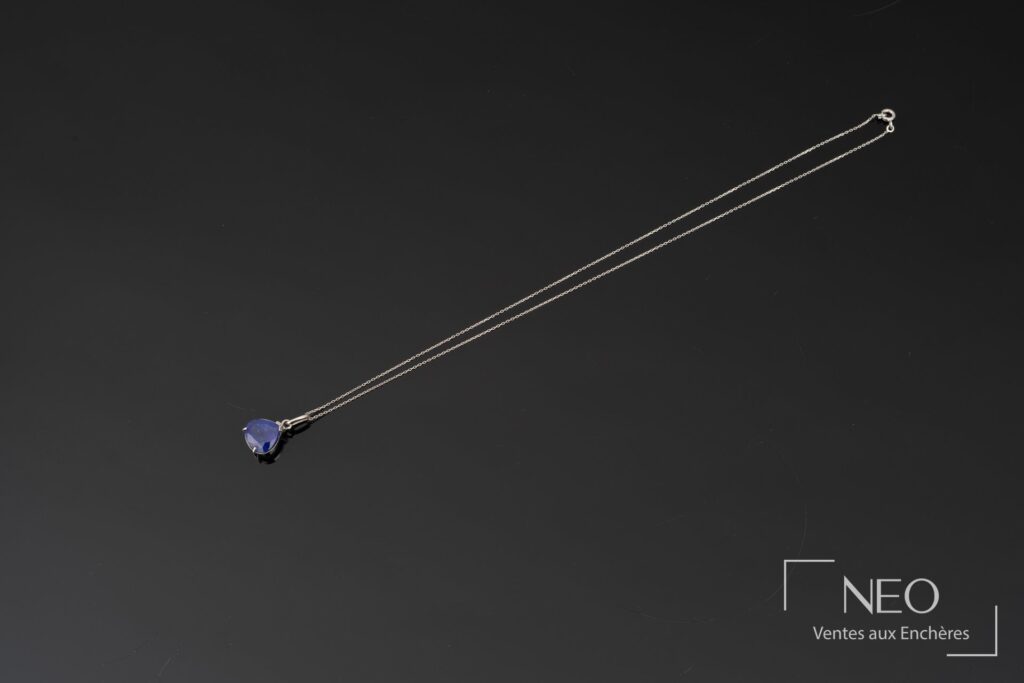 Collier en or blanc avec pendentif serti d'une tanzanite poire sur fond noir