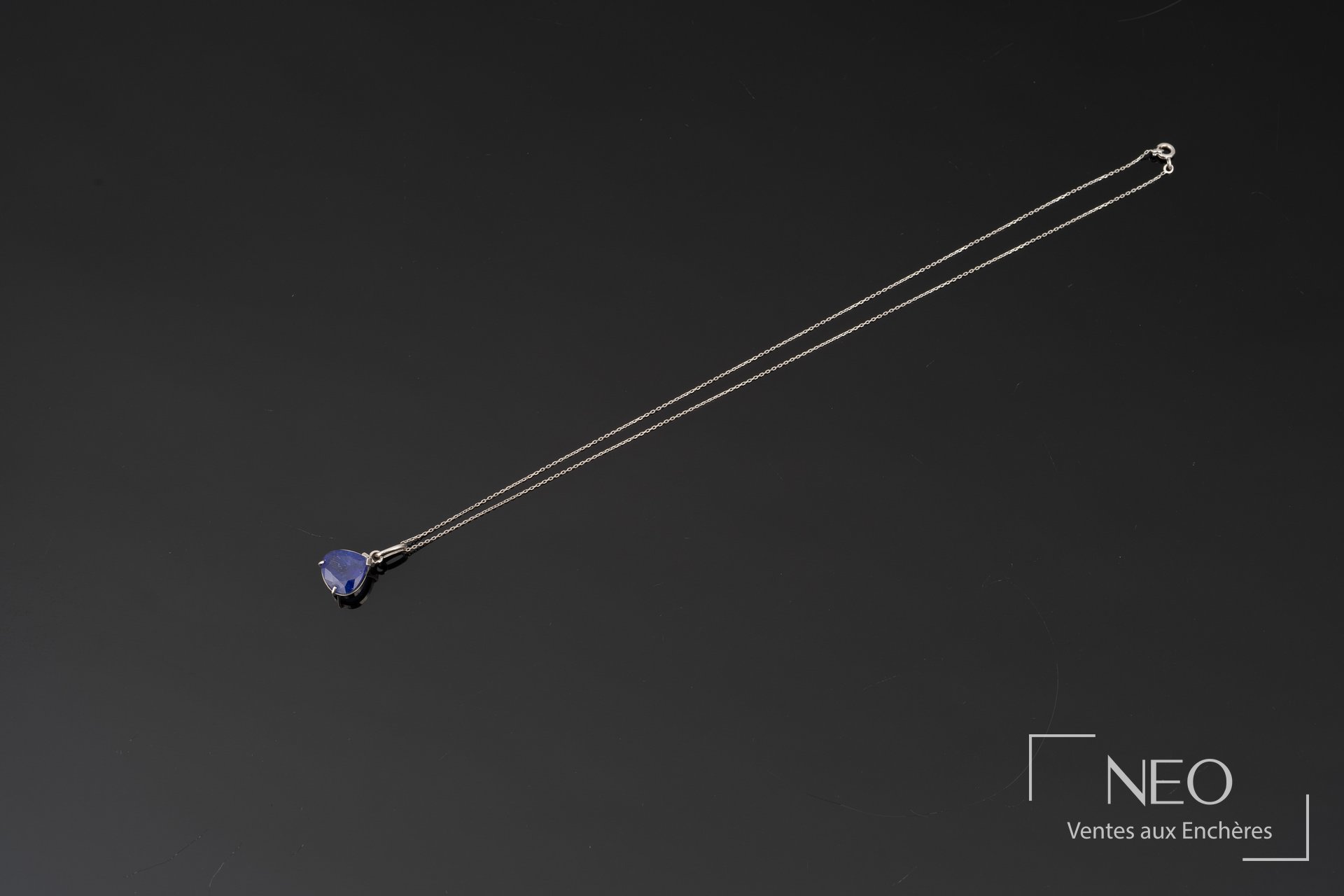 Collier en or blanc avec pendentif serti d'une tanzanite poire sur fond noir