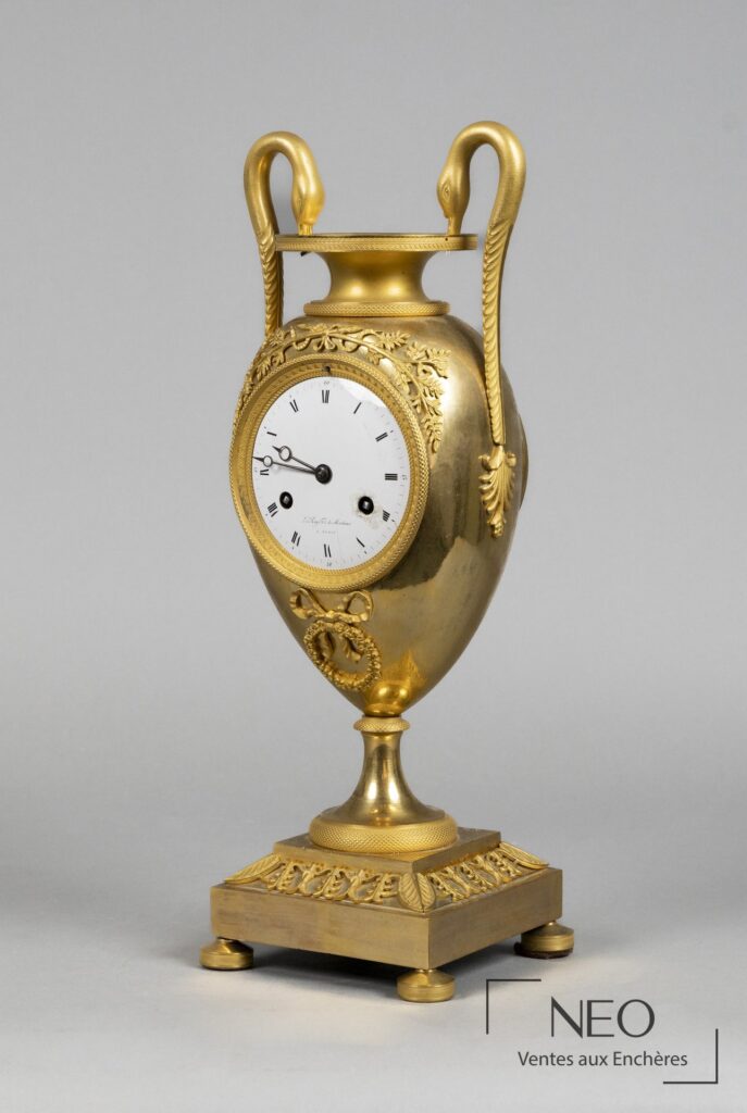 Pendule amphore en bronze doré avec cadran émaillé blanc et décor de cols de cygne