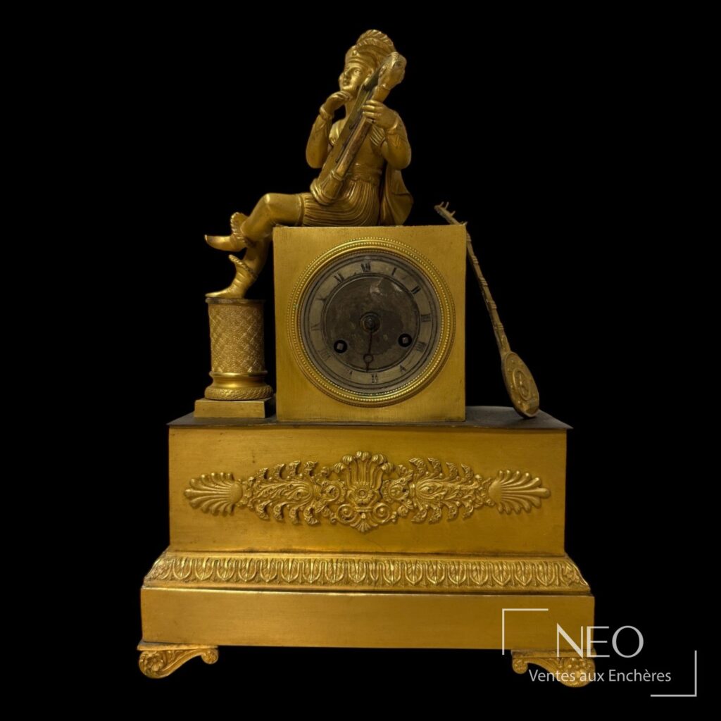 Pendule dorée avec joueur de harpe et cadran rond à chiffres romains