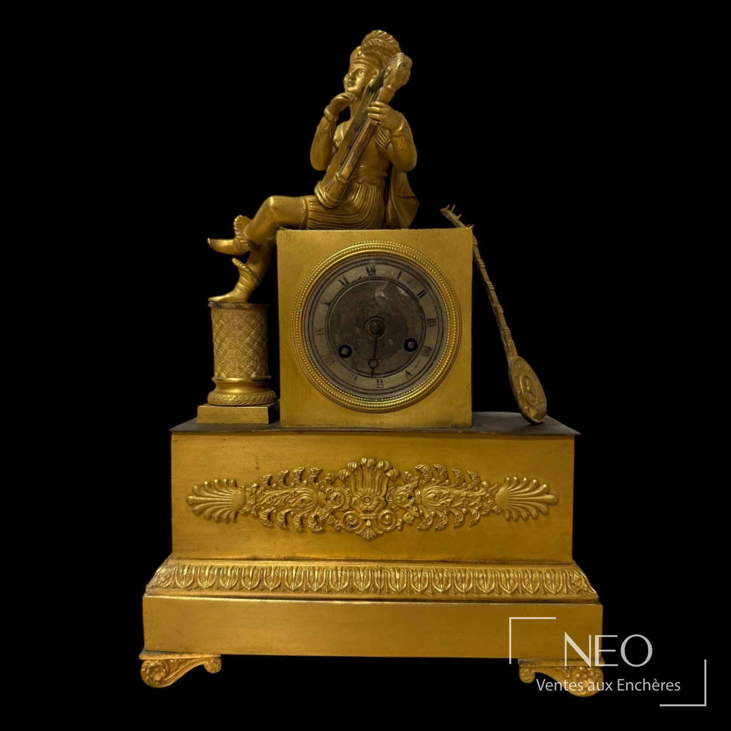 Pendule dorée avec joueur de harpe et cadran rond à chiffres romains