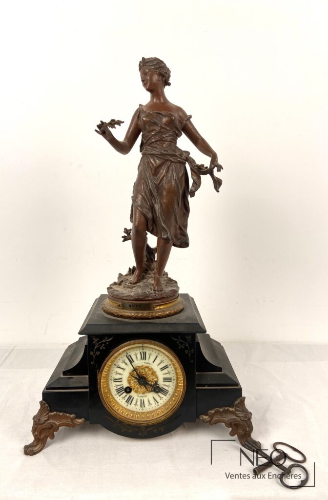 Pendule en marbre noir surmontée d'une statuette en régule