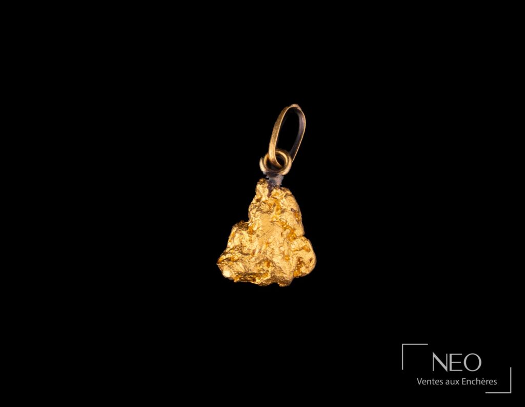 Pépite en or jaune montée en pendentif sur fond noir