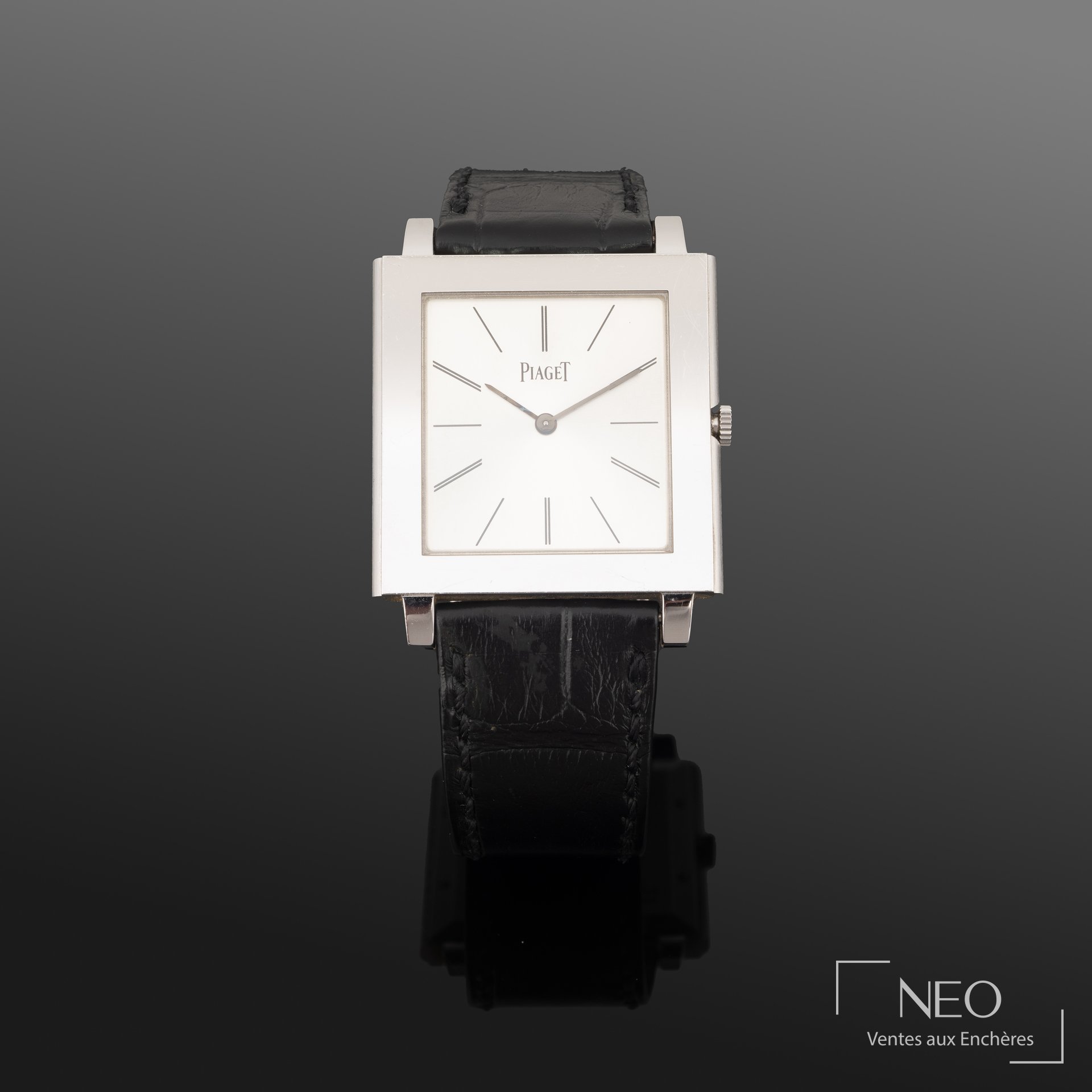 Montre Piaget carrée en or gris avec cadran argenté et bracelet cuir noir.