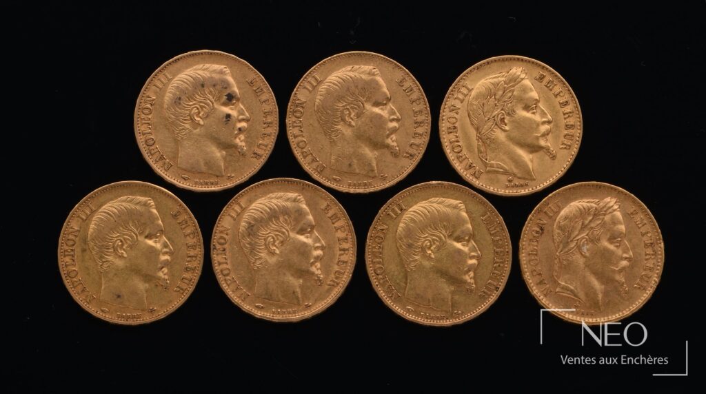 Sept pièces en or Napoléon III posées sur fond noir