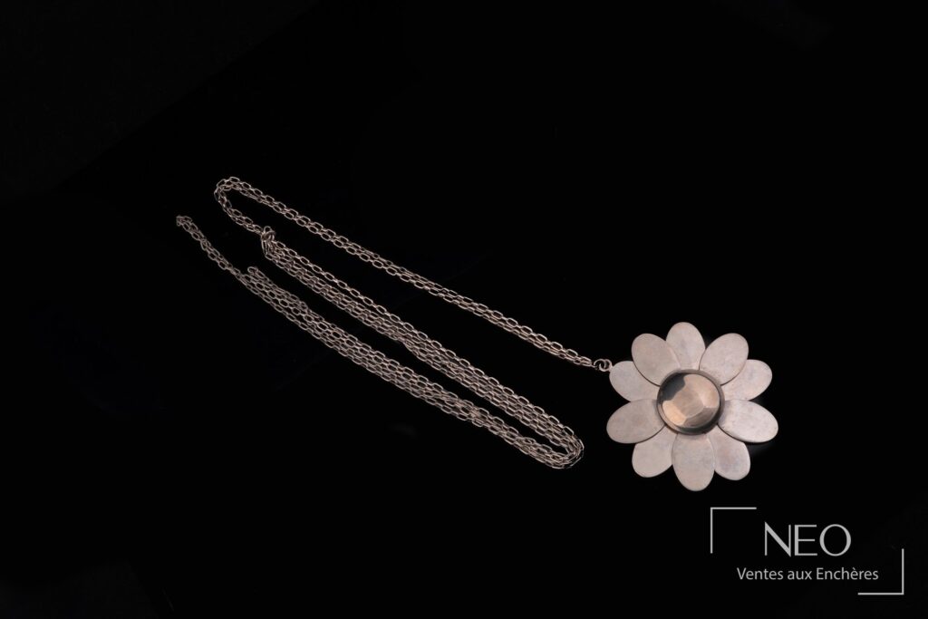 Long collier Pierre Cardin avec pendentif marguerite en métal patiné sur fond noir