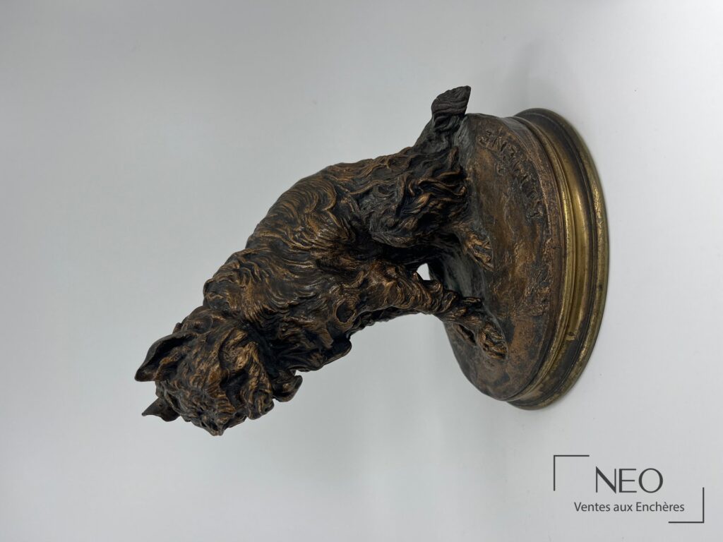 Griffon en bronze patiné vu de profil sur socle circulaire.