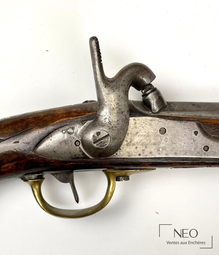 Gros plan sur la platine gravée et le chien d'un pistolet à percussion