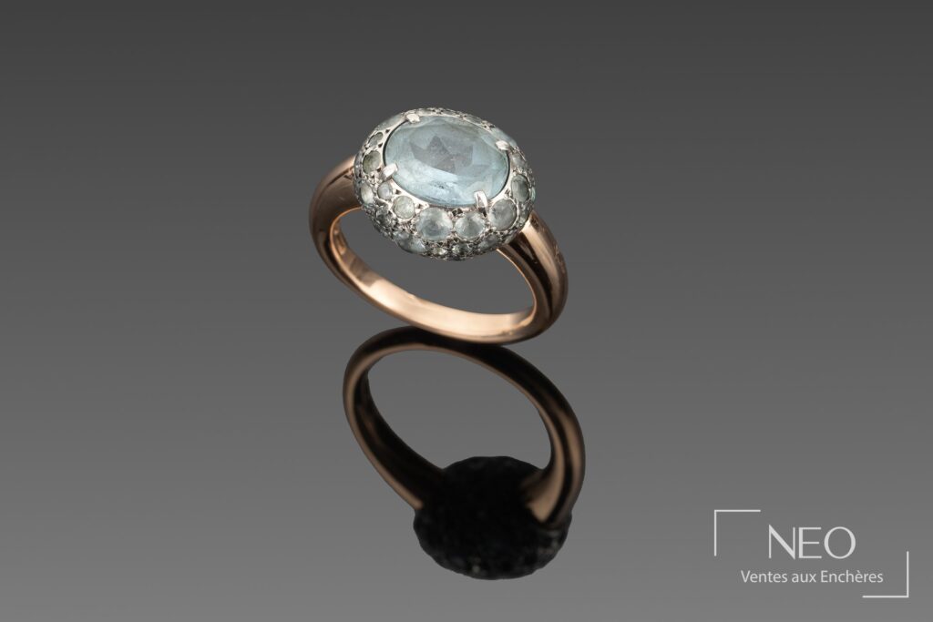 Bague Pomellato en or rose avec motif pavé de topazes bleues et pierre ovale centrale