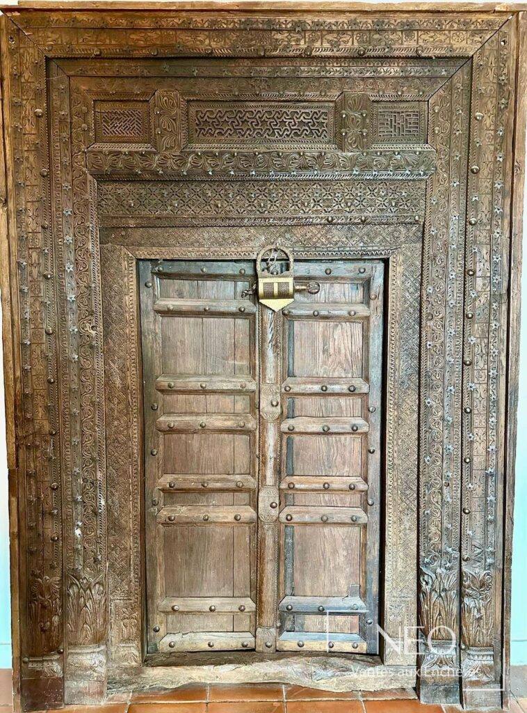 Porte en bois sculpté à deux vantaux avec encadrement richement ajouré