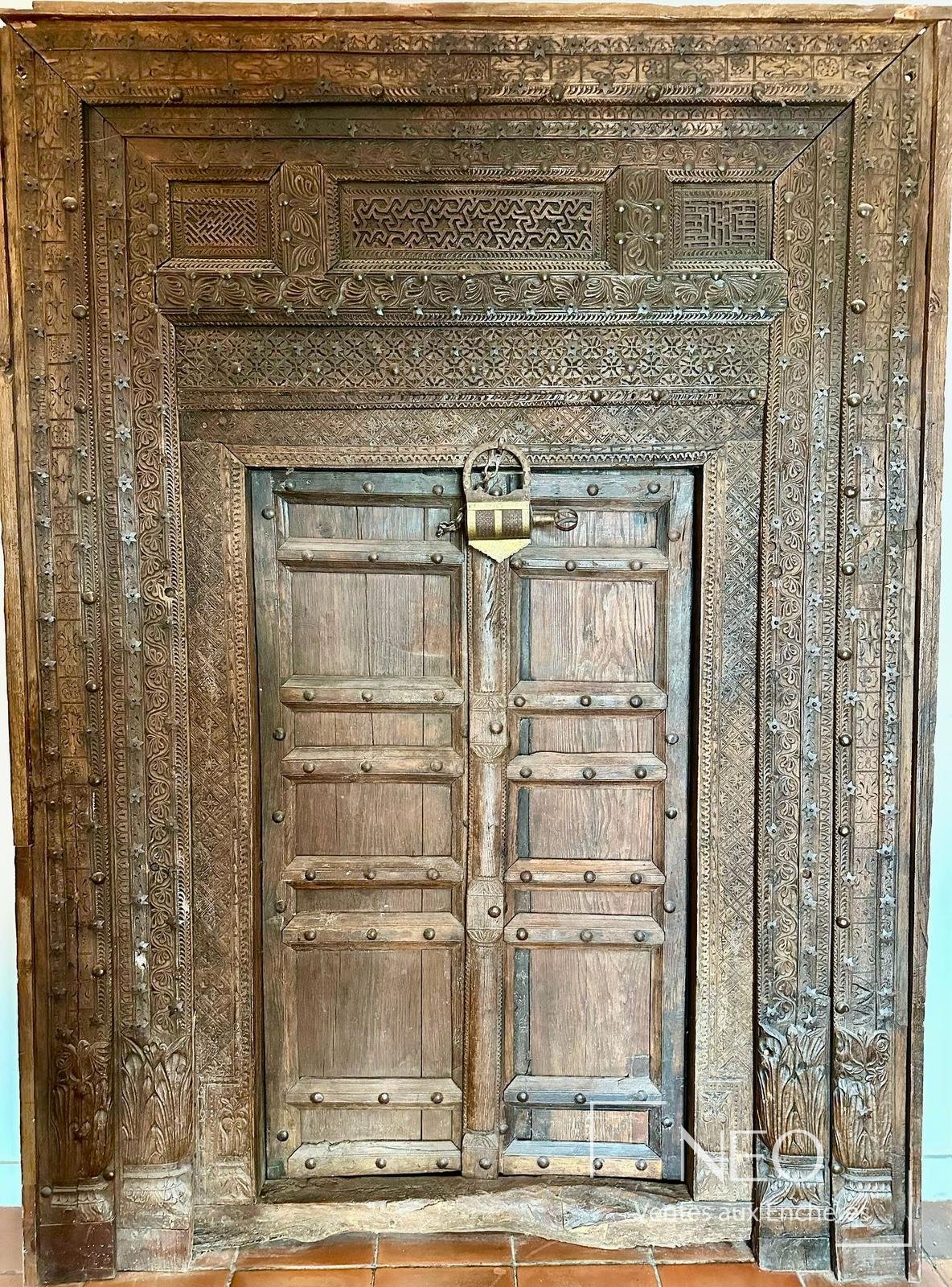 Porte en bois sculpté à deux vantaux avec encadrement richement ajouré