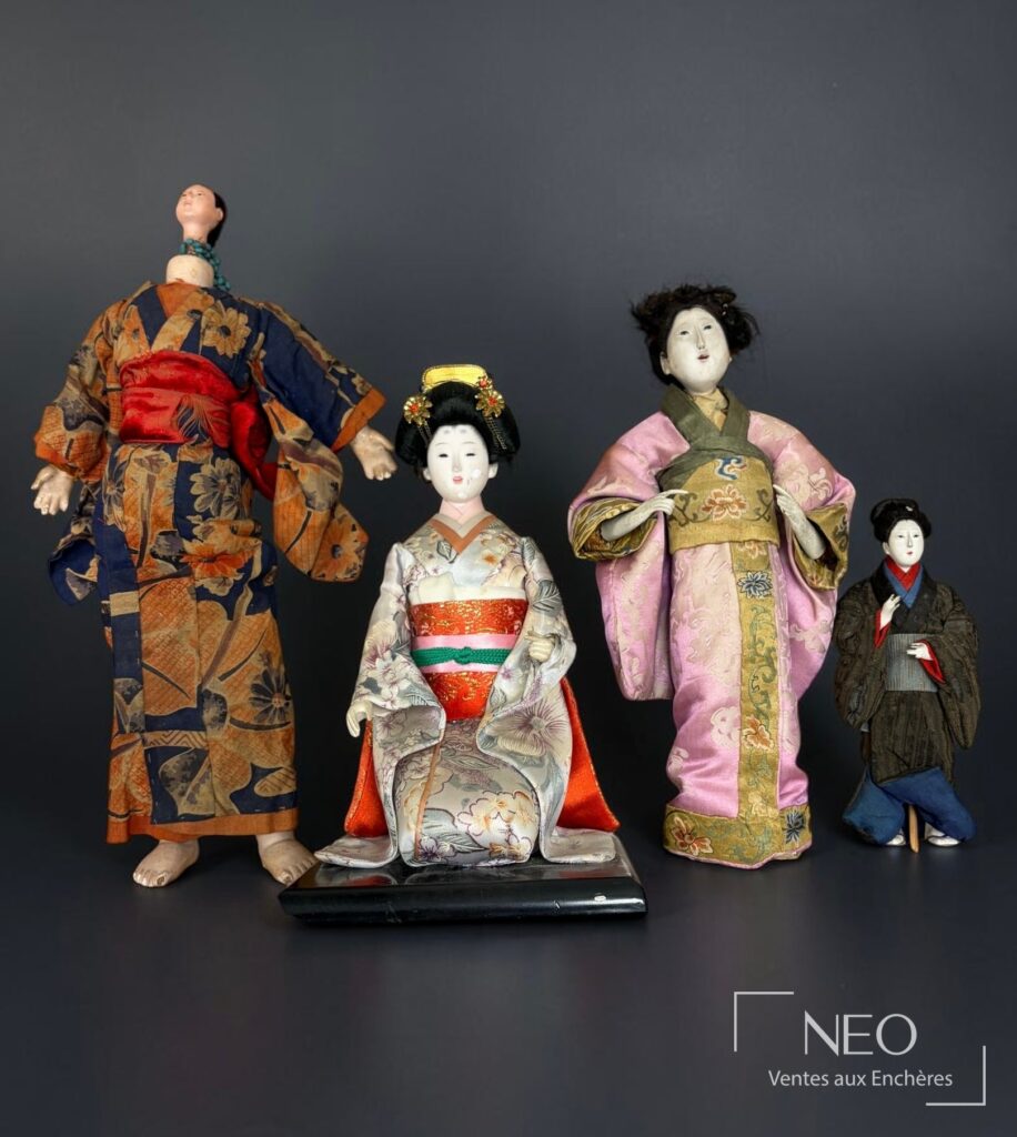 Ensemble de quatre poupées japonaises hina ningyo en vêtements de soie sur fond sombre