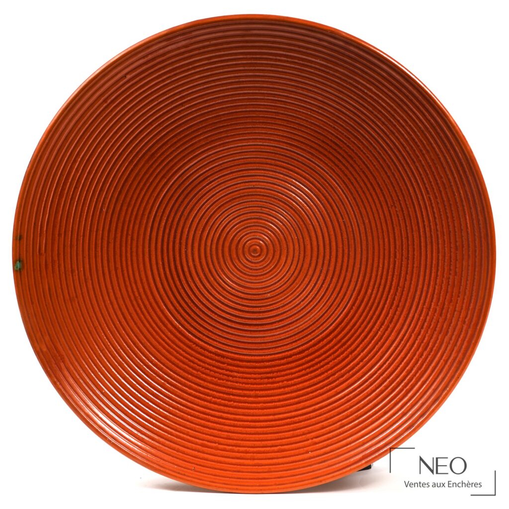 Plat circulaire rouge à décor de spirales concentriques