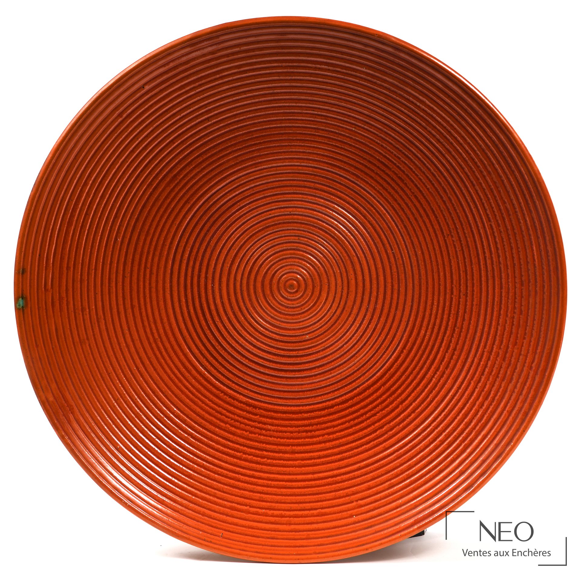 Plat circulaire rouge à décor de spirales concentriques