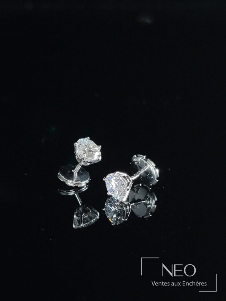 Paire de puces d'oreilles en or gris serties de diamants sur fond noir
