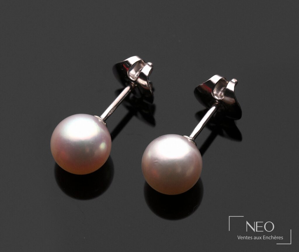 Paire de puces d’oreilles en or gris avec perles de culture blanches sur fond noir