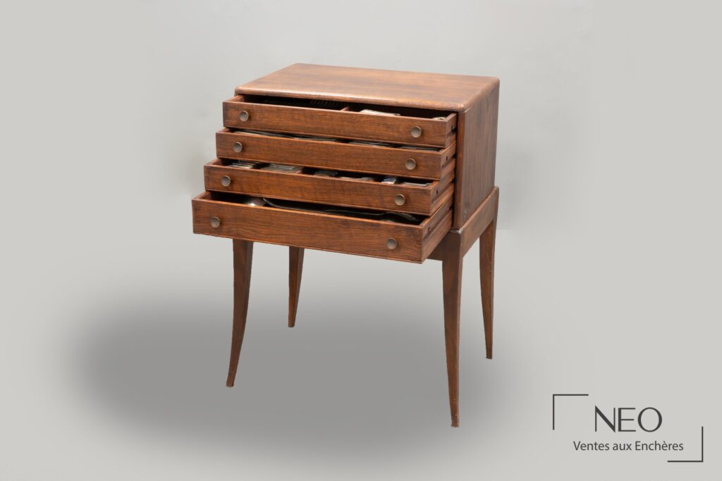 Meuble-coffret en bois ouvert avec plusieurs tiroirs et couverts en argent visibles