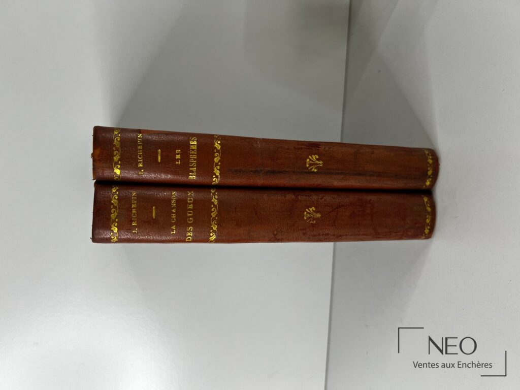 Deux dos de livres reliés en demi chagrin rouge avec titres dorés
