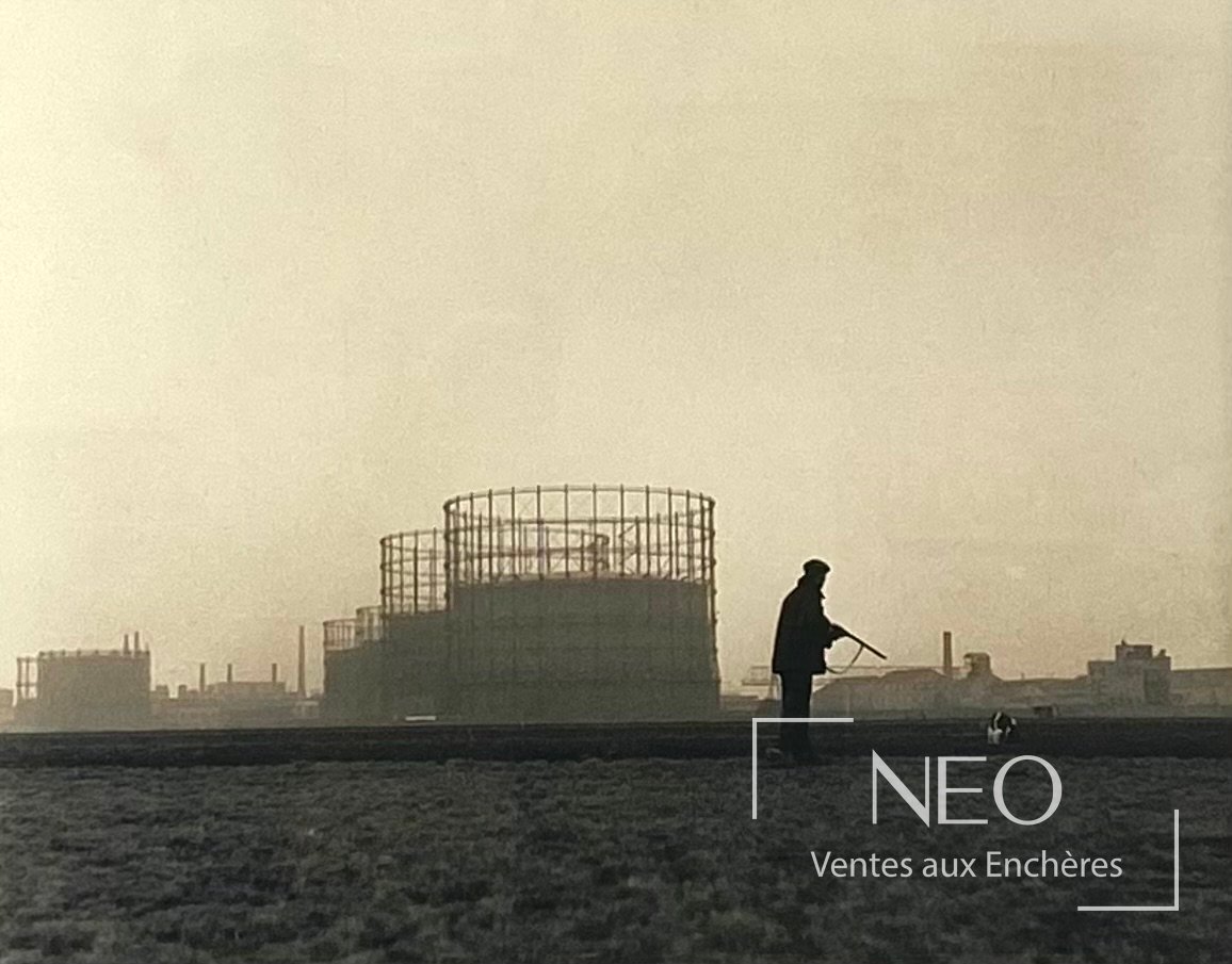 Tirage photographique de Robert Doisneau montrant un chasseur en silhouette dans un paysage industriel