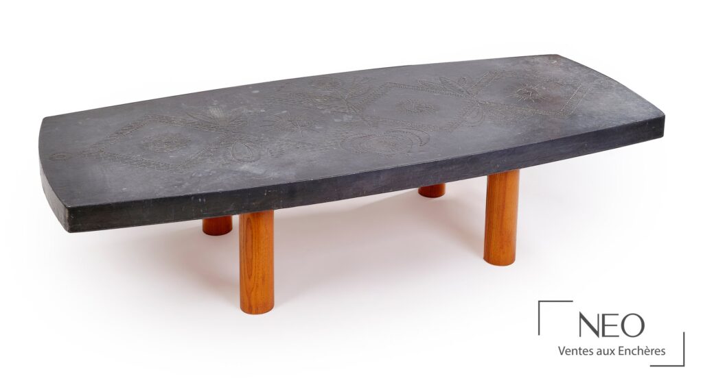 Table basse rectangulaire à plateau noir décoré de motifs repoussés et pieds cylindriques en bois