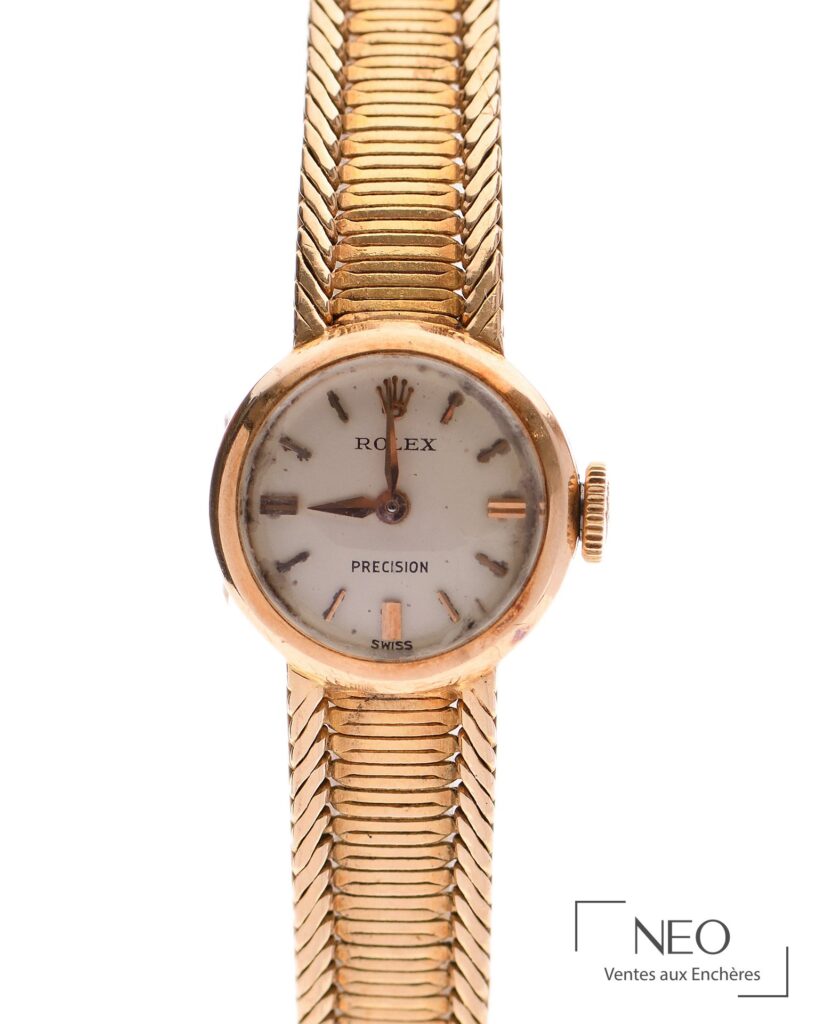 Montre-bracelet Rolex en or jaune avec cadran crème signé et bracelet à mailles serpent.
