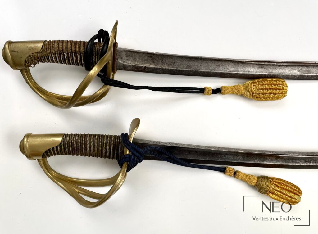 Sabre de cavalerie légère avec garde en métal jaune et dragonne noire et or