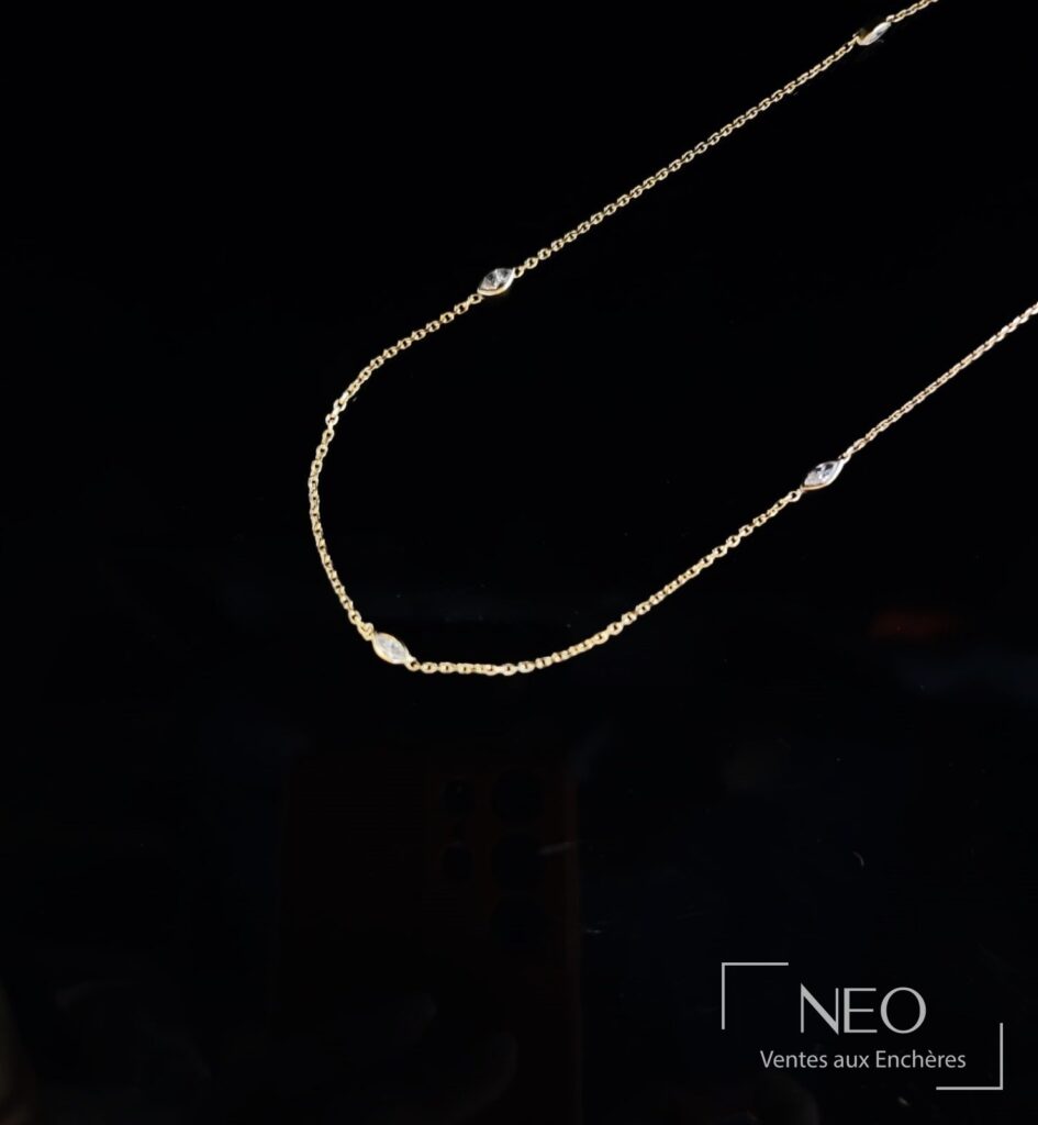 Sautoir en or jaune avec diamants taille navette sur fond noir
