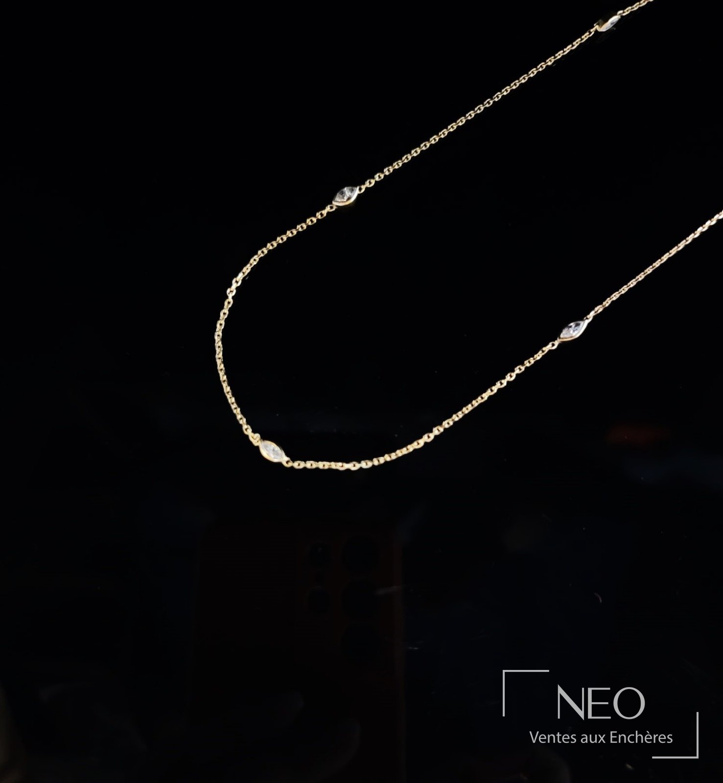 Sautoir en or jaune avec diamants taille navette sur fond noir