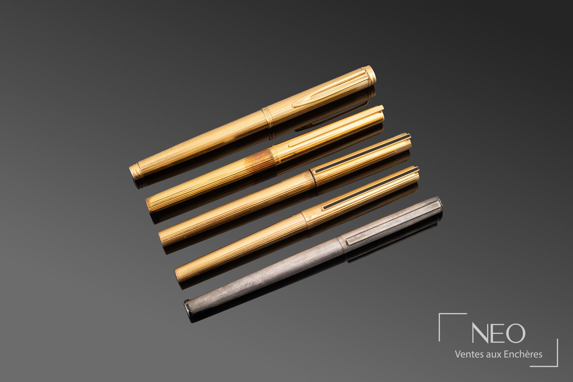 Cinq stylos alignés