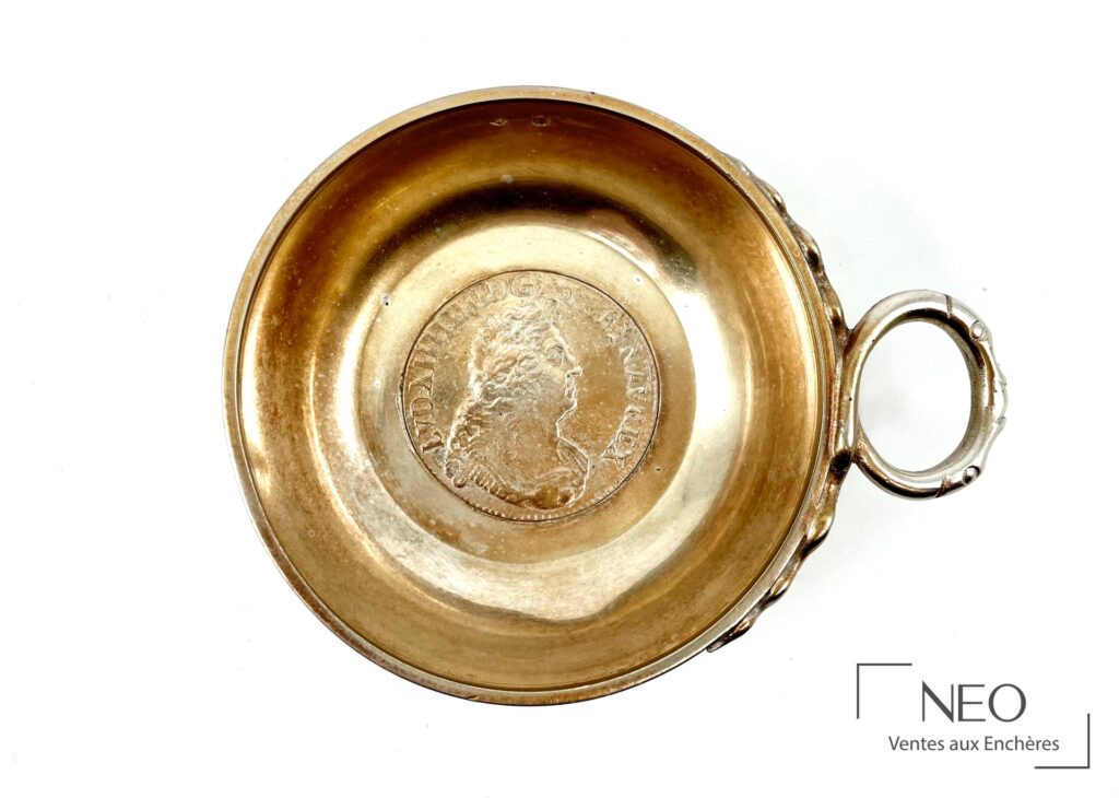 Intérieur d’un tastevin en argent avec médaillon central gravé et anse à droite