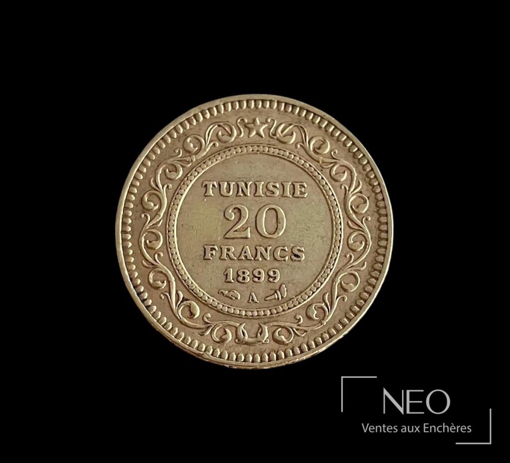 Avers d'une pièce tunisienne de 20 francs or datée 1899 sur fond noir.