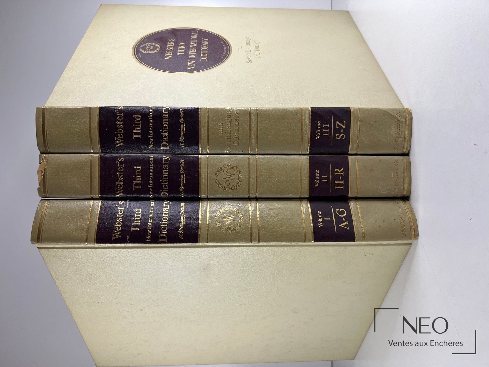 Trois volumes Webster's Third rangés avec leur coffret beige