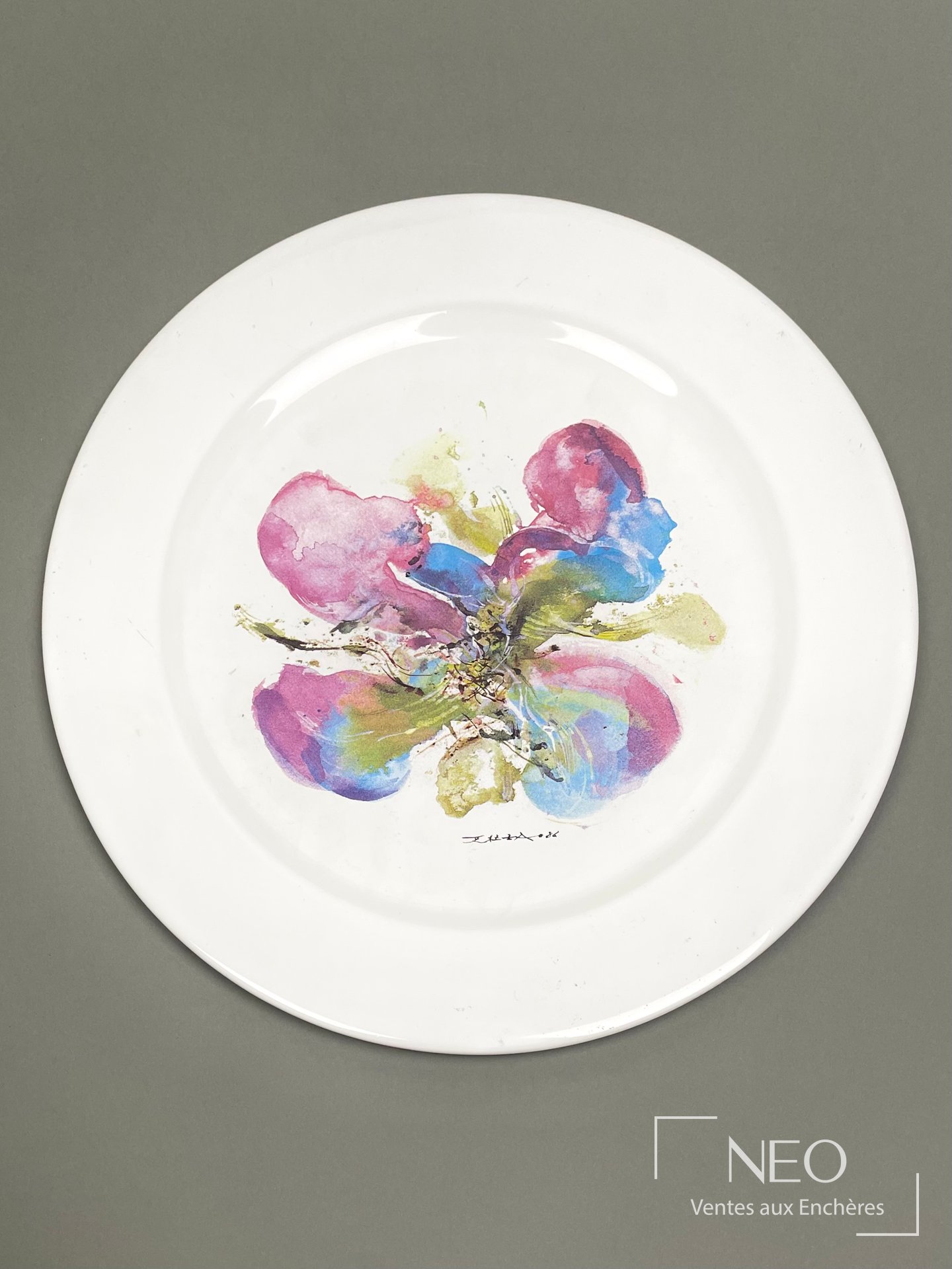 Assiette large en faïence blanche au décor floral polychrome centré