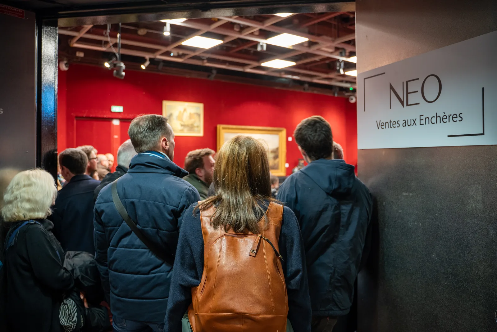 Visiteurs entrant dans la salle de vente NEO Enchères à l'Hôtel Drouot