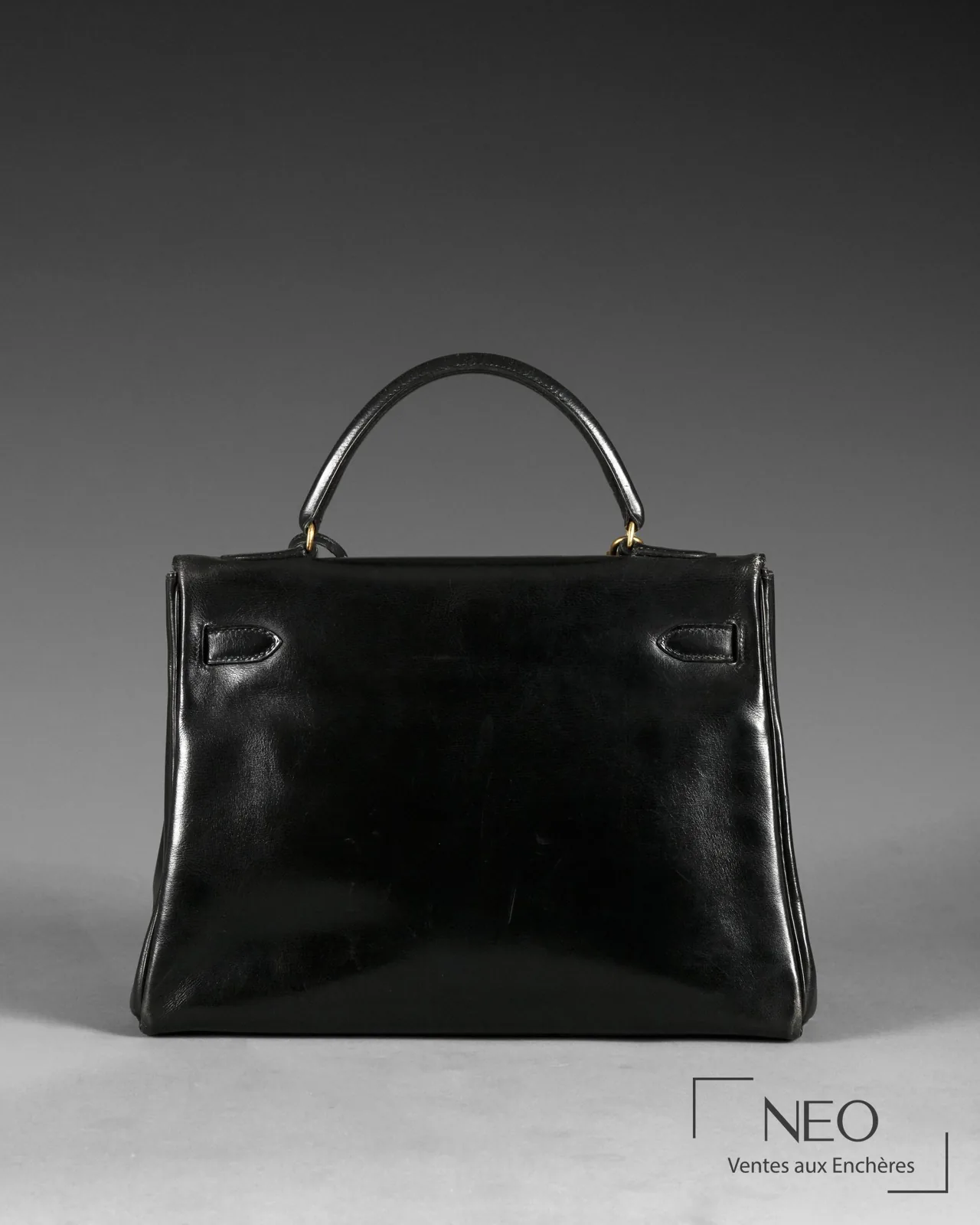 Dos d'un sac Kelly Hermès 32 en veau box noir lisse, examen du cuir et des coutures