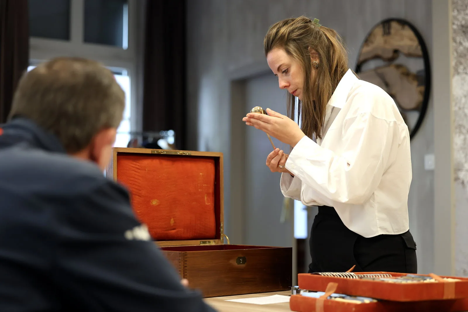 Spécialiste NEO Enchères examinant une pièce d'argenterie lors d'une journée d'estimation gratuite à Clermont-Ferrand